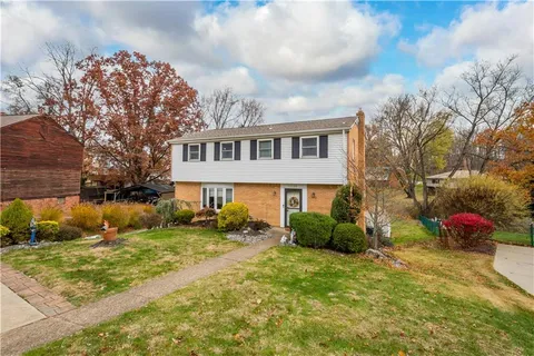 a front view of house with yard and trees around