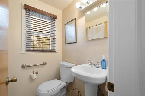 a bathroom with a sink a toilet and mirror