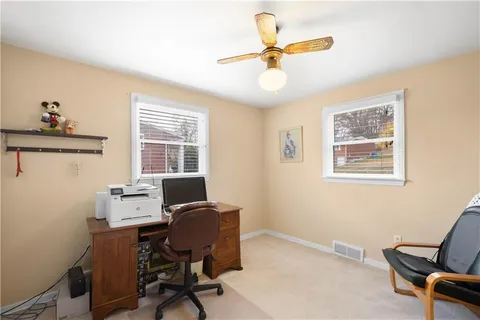 a view of a workspace with furniture and a window