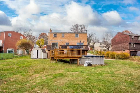 a view of a house with a big yard and large trees