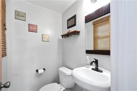 a bathroom with a sink mirror and toilet