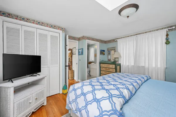 a bedroom with a bed and a flat tv screen in it