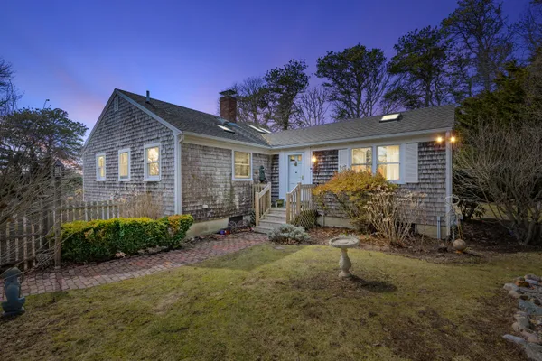 a view of a house with a small yard and potted plants