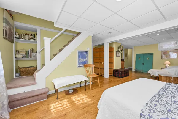 a spacious bedroom with wooden floor and furniture