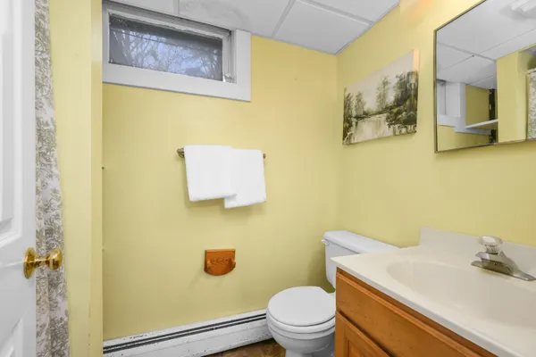a bathroom with a toilet sink vanity and mirror