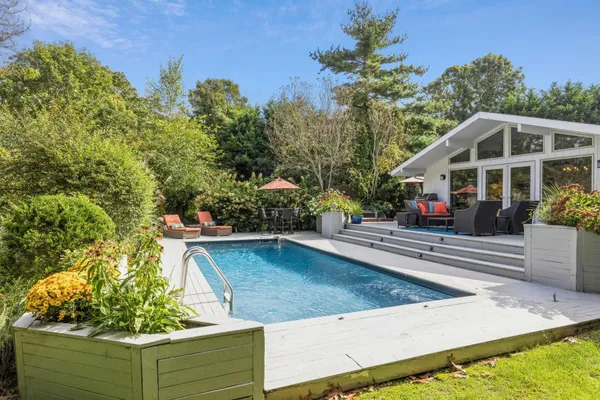 swimming pool view with a seating space and garden view