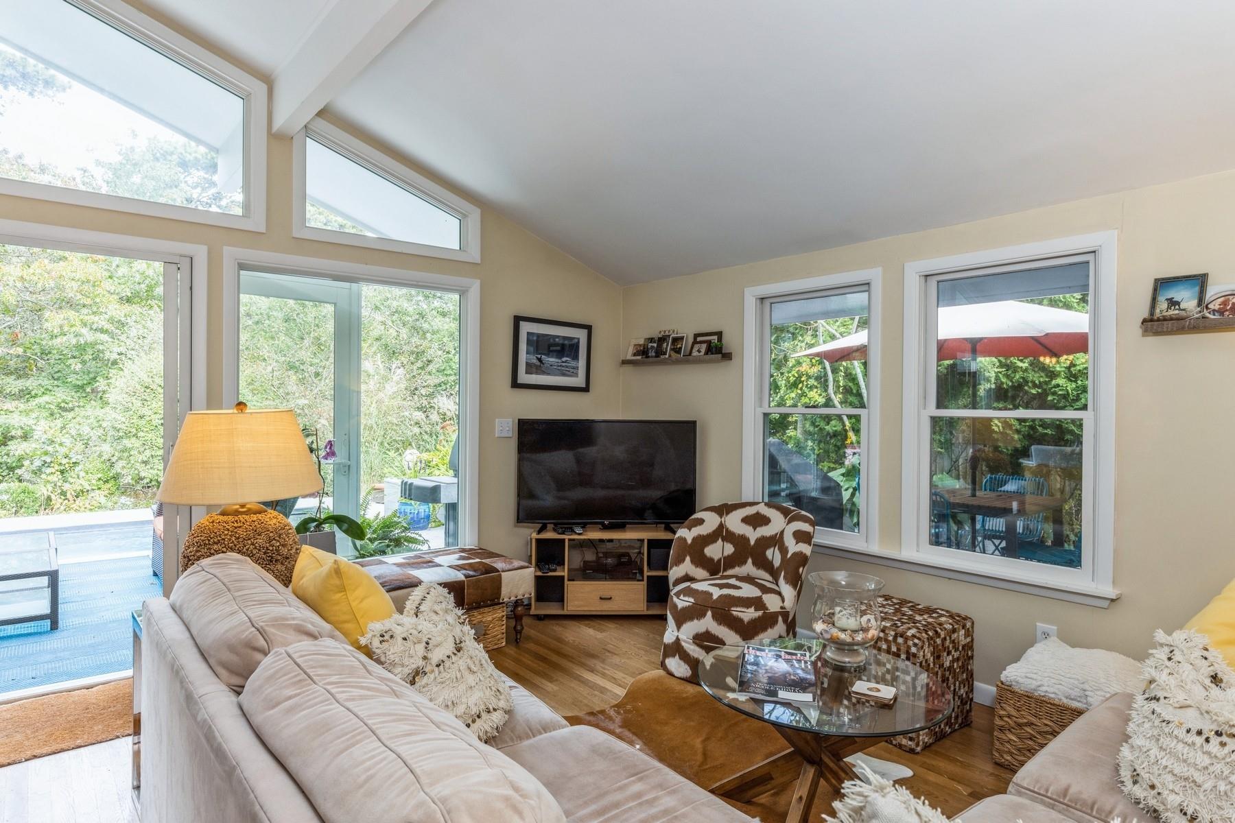 21 Hillover Road East Hampton Bays, NY 11946 - Photo 12 of 33 a living room with furniture a flat screen tv and a large window