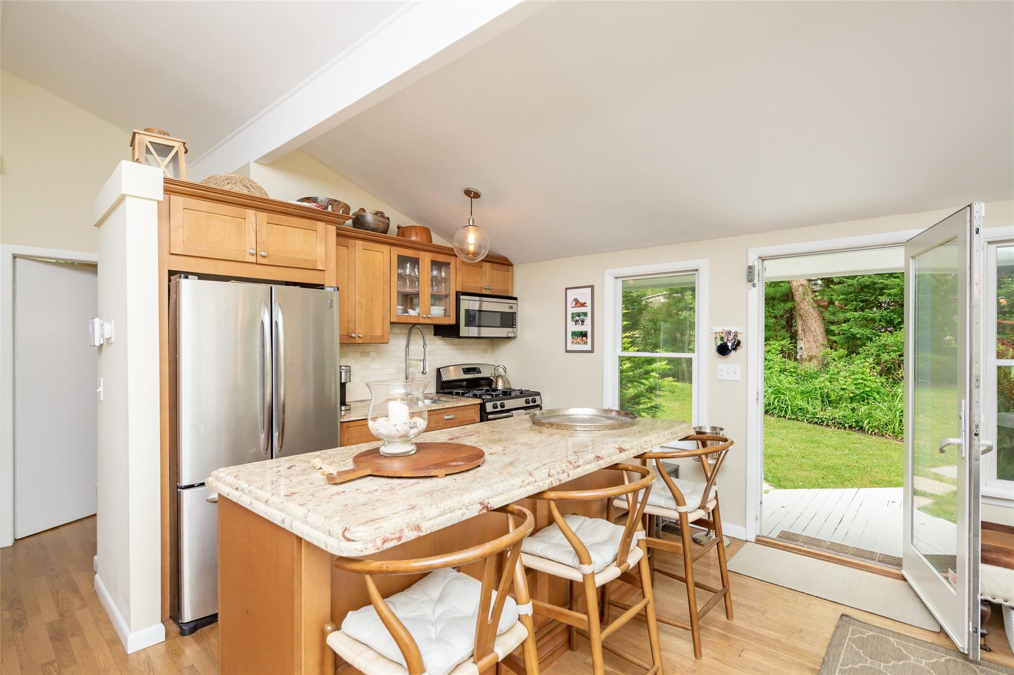 21 Hillover Road East Hampton Bays, NY 11946 - Photo 13 of 33 a kitchen with a stove a refrigerator and a dining table