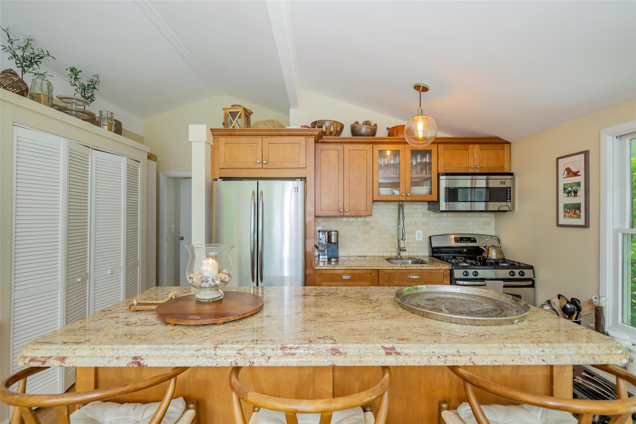 21 Hillover Road East Hampton Bays, NY 11946 - Photo 15 of 33 a kitchen with kitchen island granite countertop a sink a stove and cabinets