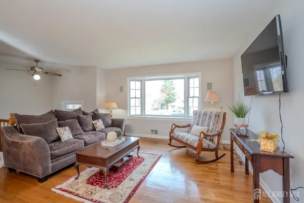 a living room with furniture a flat screen tv and a large window