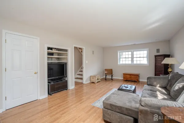 a living room with furniture and a flat screen tv with wooden floor