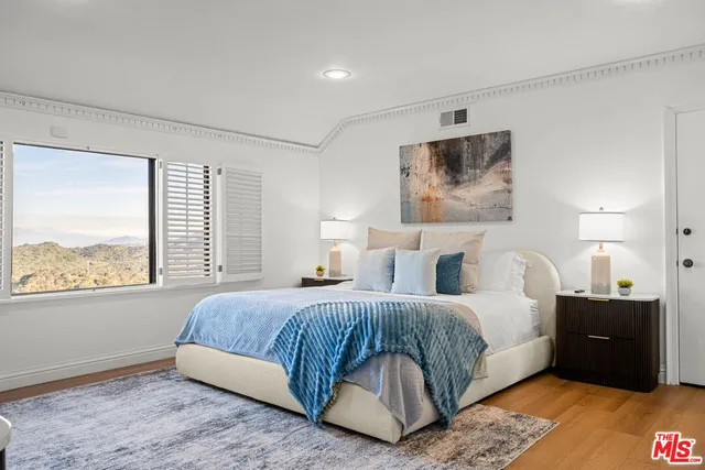 a view of a white house with a big yard and potted plants