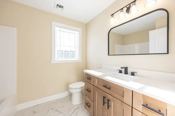 a bathroom with a toilet sink and mirror