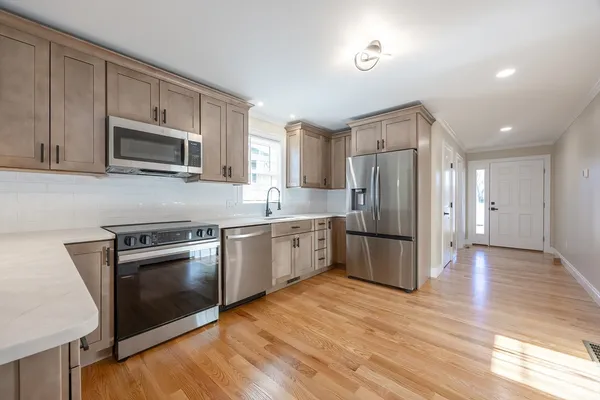 a kitchen with granite countertop stainless steel appliances and wooden cabinets
