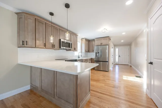 a kitchen with kitchen island white cabinets and stainless steel appliances