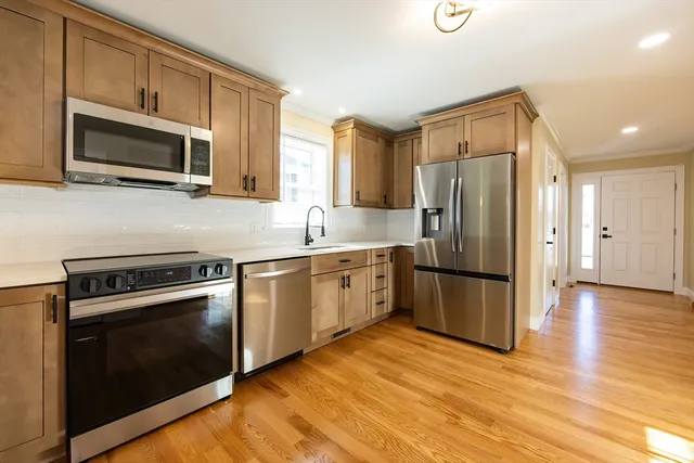 a kitchen with kitchen island granite countertop wooden cabinets and white appliances