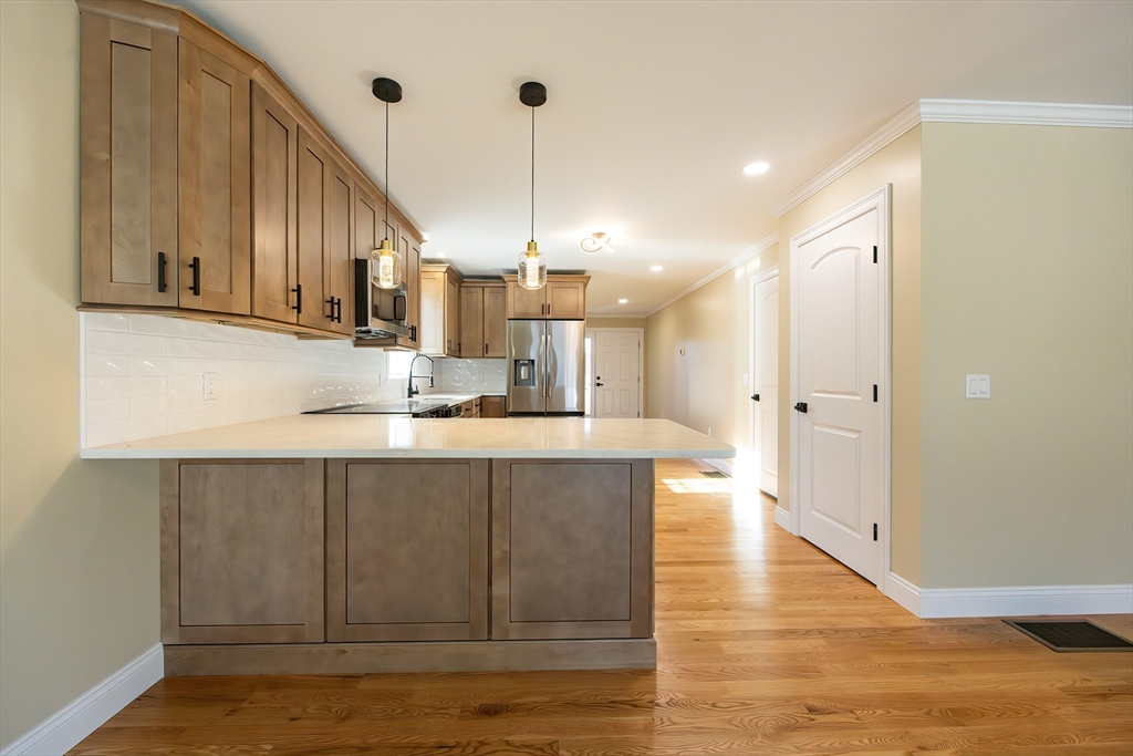 50 Pullman Avenue, Unit B Attleboro, MA 02703 - Photo 6 of 28 a kitchen with kitchen island granite countertop wooden cabinets and white appliances