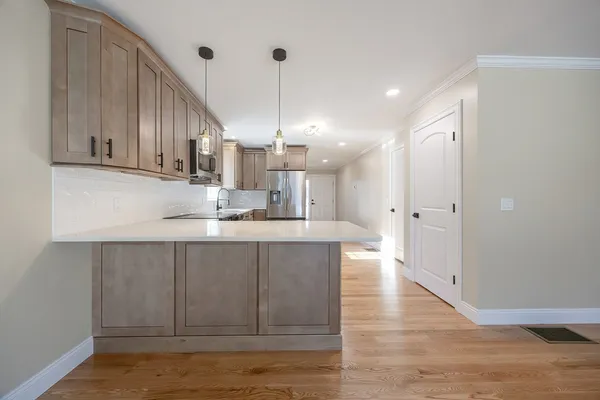 a kitchen with kitchen island granite countertop wooden cabinets and white appliances