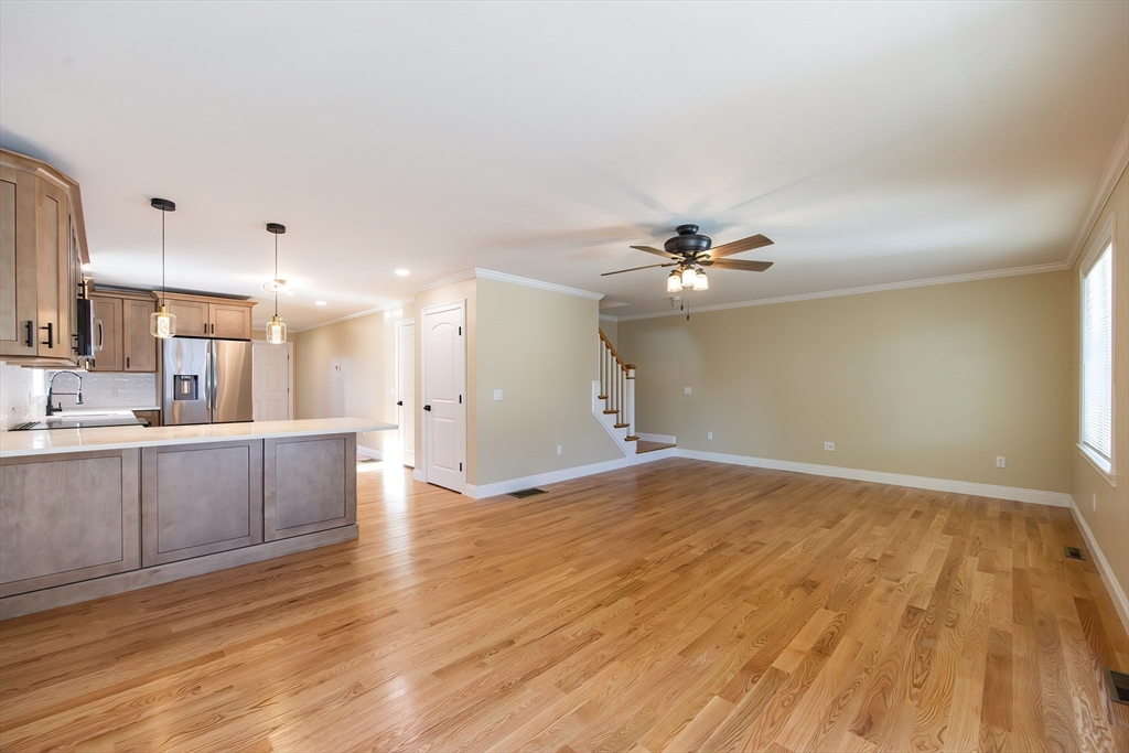 50 Pullman Avenue, Unit B Attleboro, MA 02703 - Photo 8 of 28 a view of a kitchen with kitchen island a sink wooden floor and a refrigerator