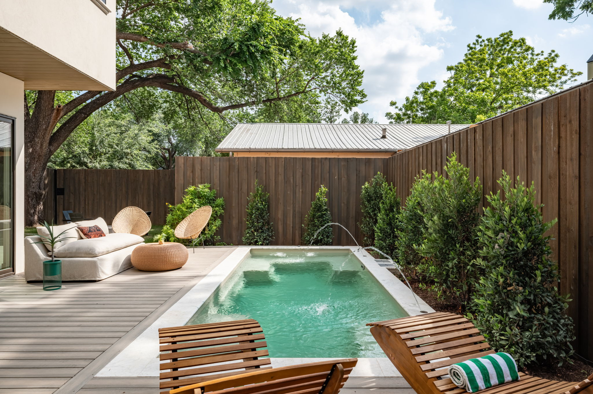4713 Bolm Road Austin, TX 78702 - Photo 3 of 40 Patio deck featuring an integrated rectangular pool with fountains, surrounded by mature trees and privacy fencing