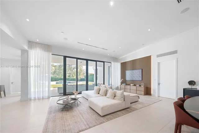 a living room with furniture and floor to ceiling window