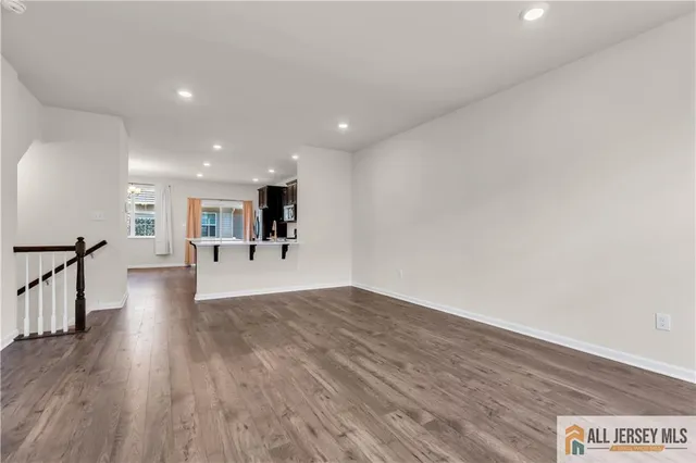 a view of a big room with wooden floor and a kitchen