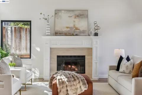 a living room with furniture a fireplace and a large window