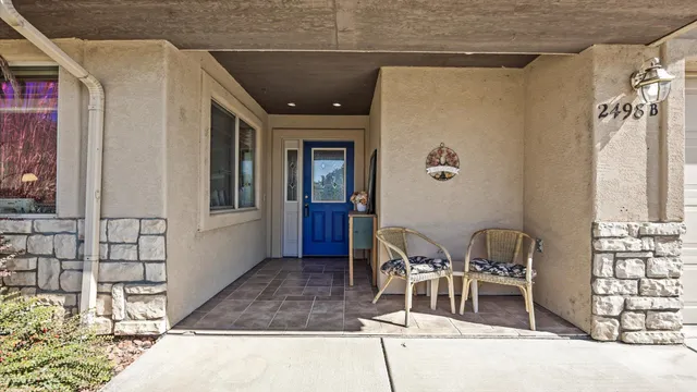 a patio with table and chairs and potted plants