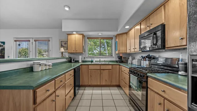 a kitchen with a sink a counter top space cabinets and stainless steel appliances