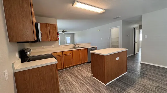 a kitchen with a stove sink and cabinets