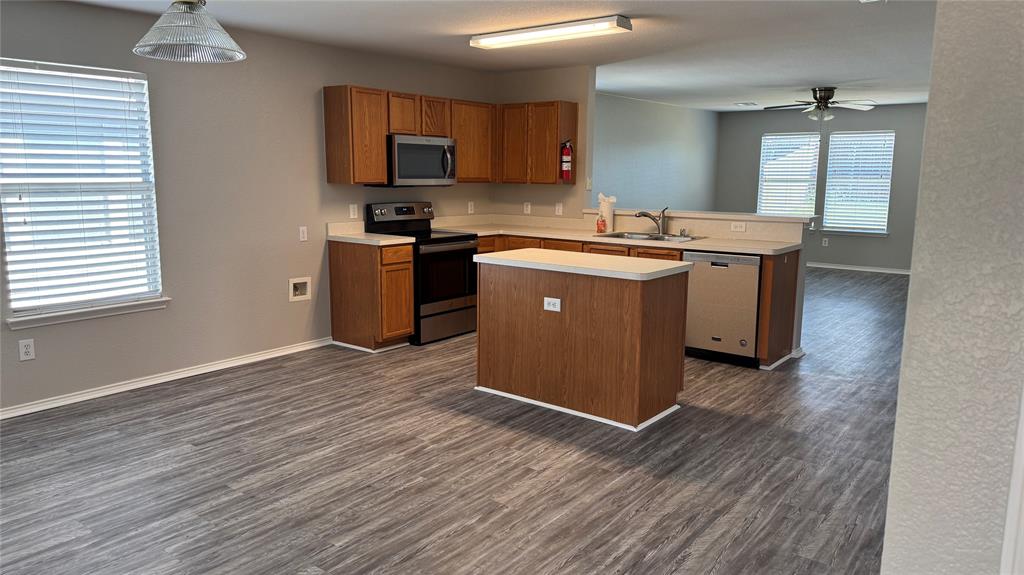 907 Post Oak Trail Anna, TX 75409 - Photo 5 of 31 a kitchen with stainless steel appliances granite countertop a sink a stove and a wooden floors