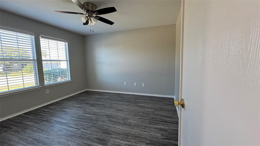 907 Post Oak Trail Anna, TX 75409 - Photo 7 of 31 an empty room with wooden floor fan and windows