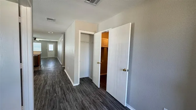 a view of a hallway with wooden floor