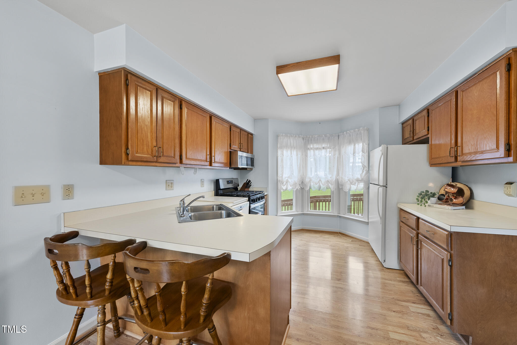 1609 Forest Road Wake Forest, NC 27587 - Photo 5 of 22 a kitchen with stainless steel appliances granite countertop a stove a refrigerator a sink dishwasher a dining table and chairs with wooden floor