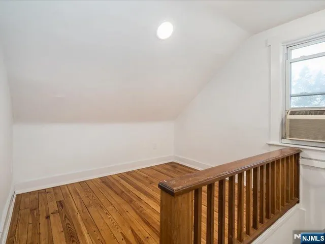 a view of a room with wooden floor and a window