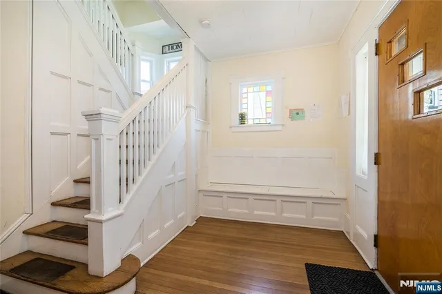 a view of entryway and hall with wooden floor