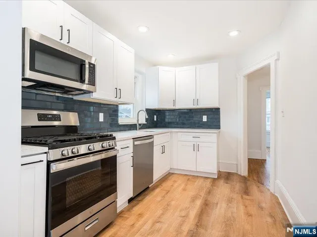 a kitchen with stainless steel appliances granite countertop a stove a microwave and cabinets