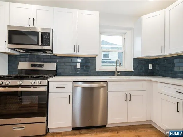 a kitchen with stainless steel appliances a stove microwave and sink
