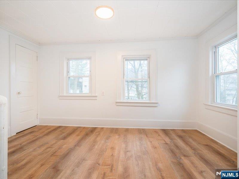 14 Ravine Avenue, Unit 2 Caldwell, NJ 07006 - Photo 9 of 23 an empty room with wooden floor and windows