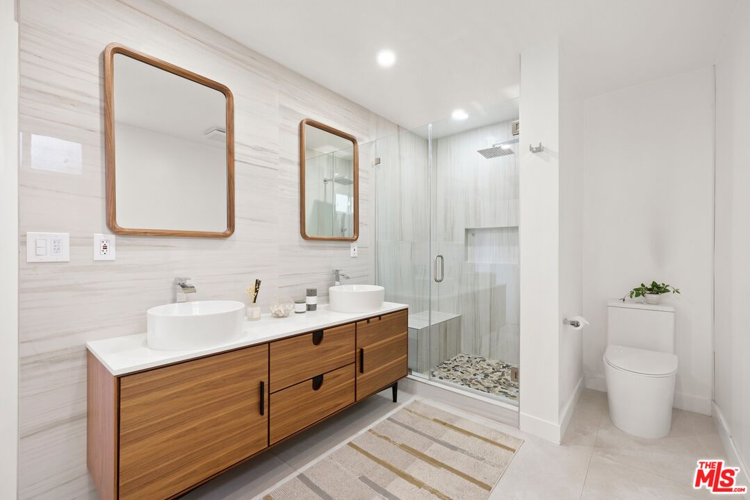 2204 Ridgemont Drive Los Angeles, CA 90046 - Photo 9 of 13 a spacious bathroom with a double vanity sink toilet and shower