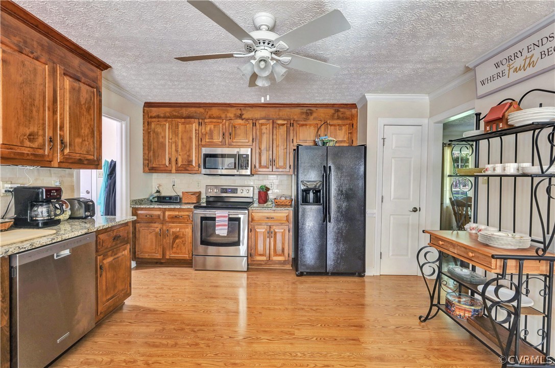 11721 2nd Branch Road Chesterfield, VA 23838 - Photo 10 of 29 a kitchen with stainless steel appliances granite countertop a refrigerator a sink dishwasher a stove with wooden cabinets and floor