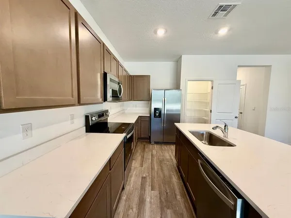 a kitchen with a sink a counter top space stainless steel appliances and cabinets