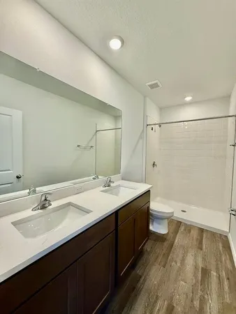 a bathroom with a double vanity sink toilet and shower