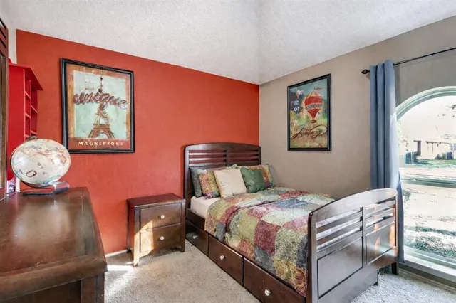 a bedroom with a bed and a painting on the wall