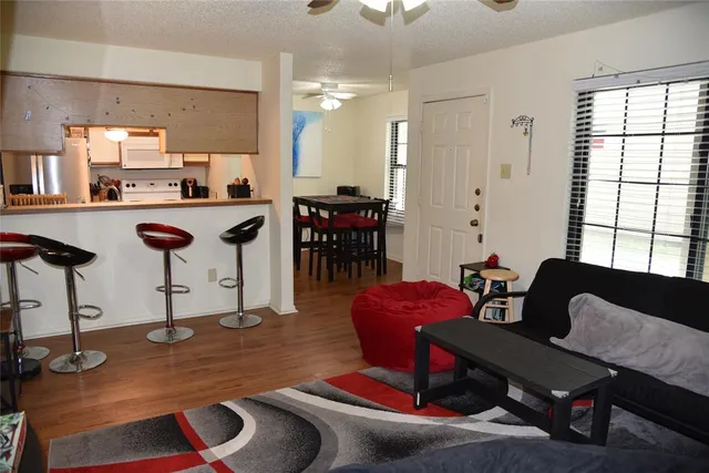 a living room with furniture a rug and kitchen view