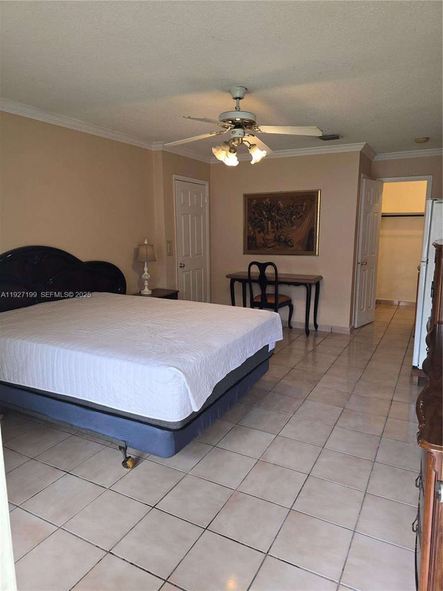 1113 Northeast 2nd Street, Unit 12 Hallandale Beach, FL 33009 - Photo 2 of 6 a bedroom with a bed and a chandelier