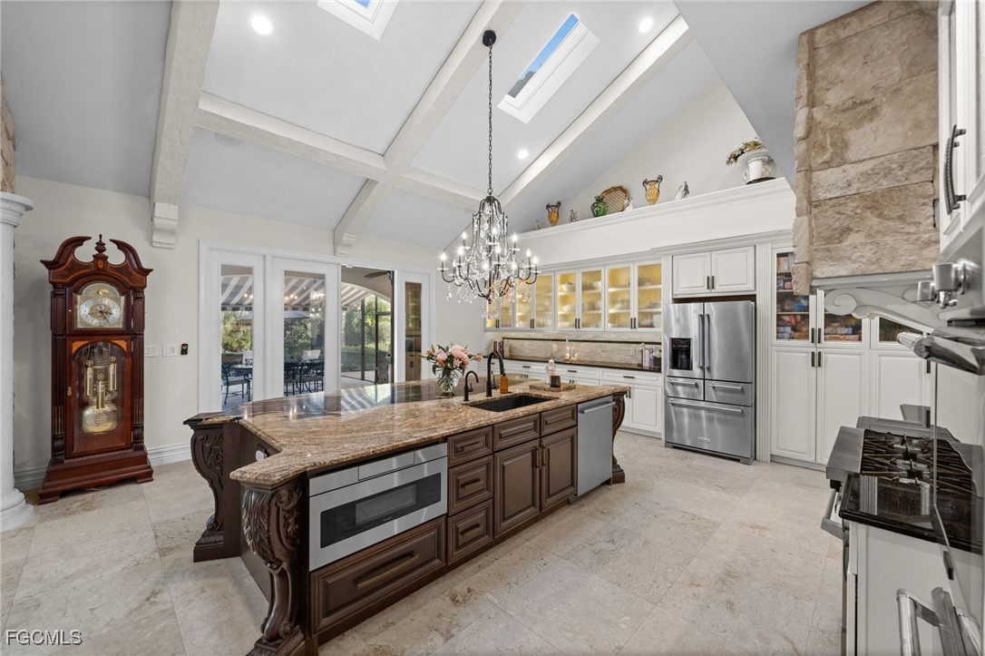 9250 The Lane Naples, FL 34109 - Photo 12 of 50 a large kitchen with stainless steel appliances kitchen island granite countertop a stove and a refrigerator