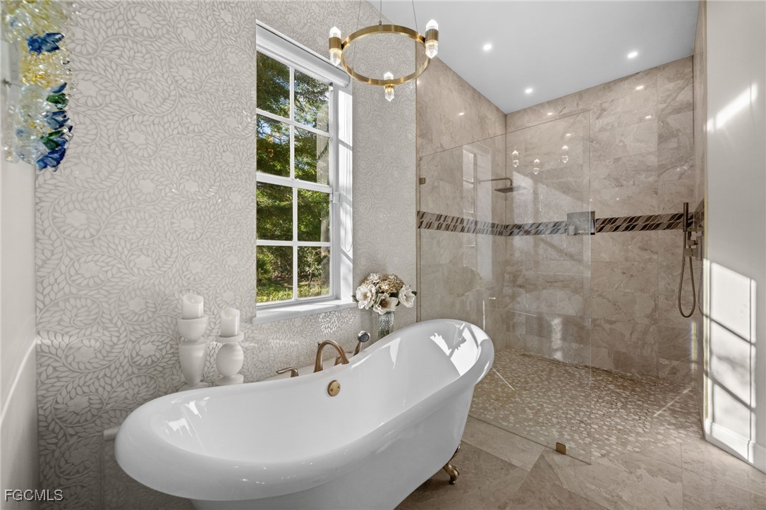 9250 The Lane Naples, FL 34109 - Photo 23 of 50 a bathroom with a tub and a shower