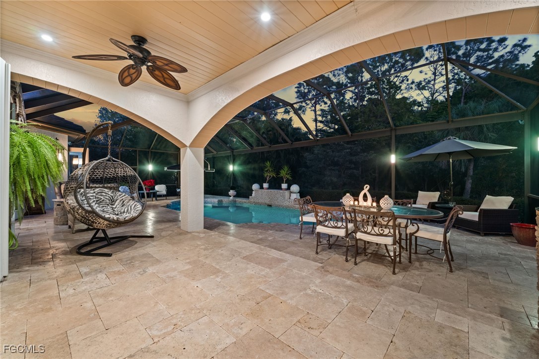 9250 The Lane Naples, FL 34109 - Photo 32 of 50 a view of a patio with a table and chairs under an umbrella