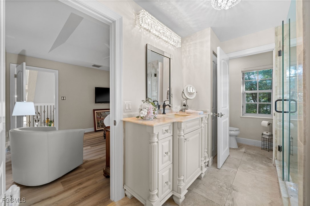 9250 The Lane Naples, FL 34109 - Photo 41 of 50 a bathroom with a double vanity sink mirror and toilet